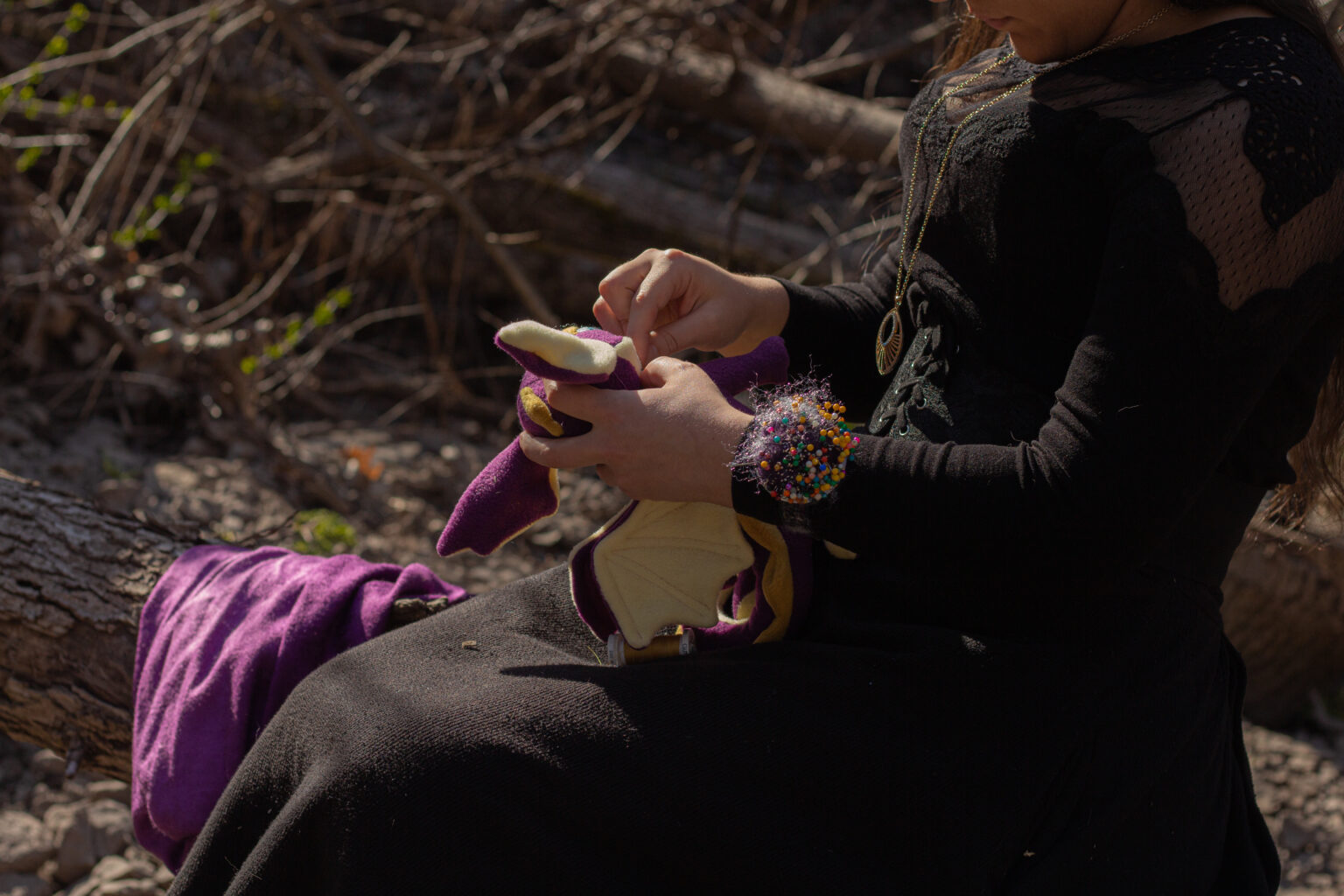 Femme cousant sur un tronc.